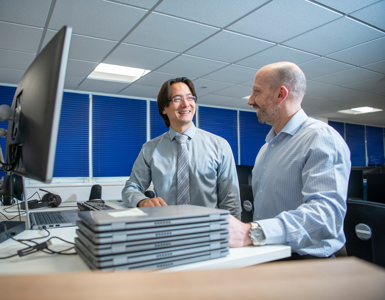 2 IT colleagues working together on laptop