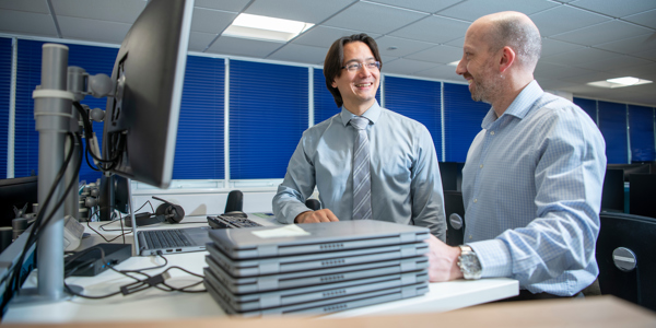 2 IT colleagues working together on laptop