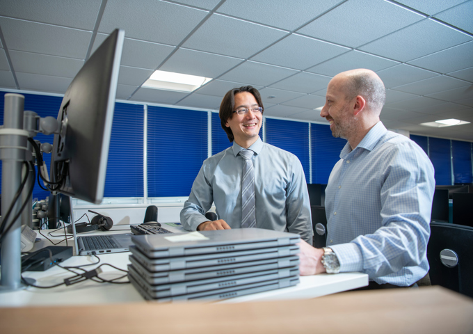 2 IT colleagues working together on laptop