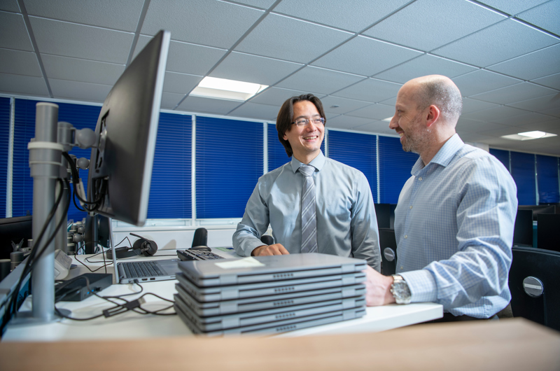 2 IT colleagues working together on laptop